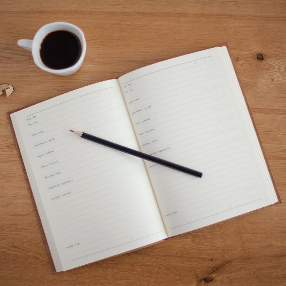 Carnet ouvert, crayon et tasse de café sur un bureau en bois